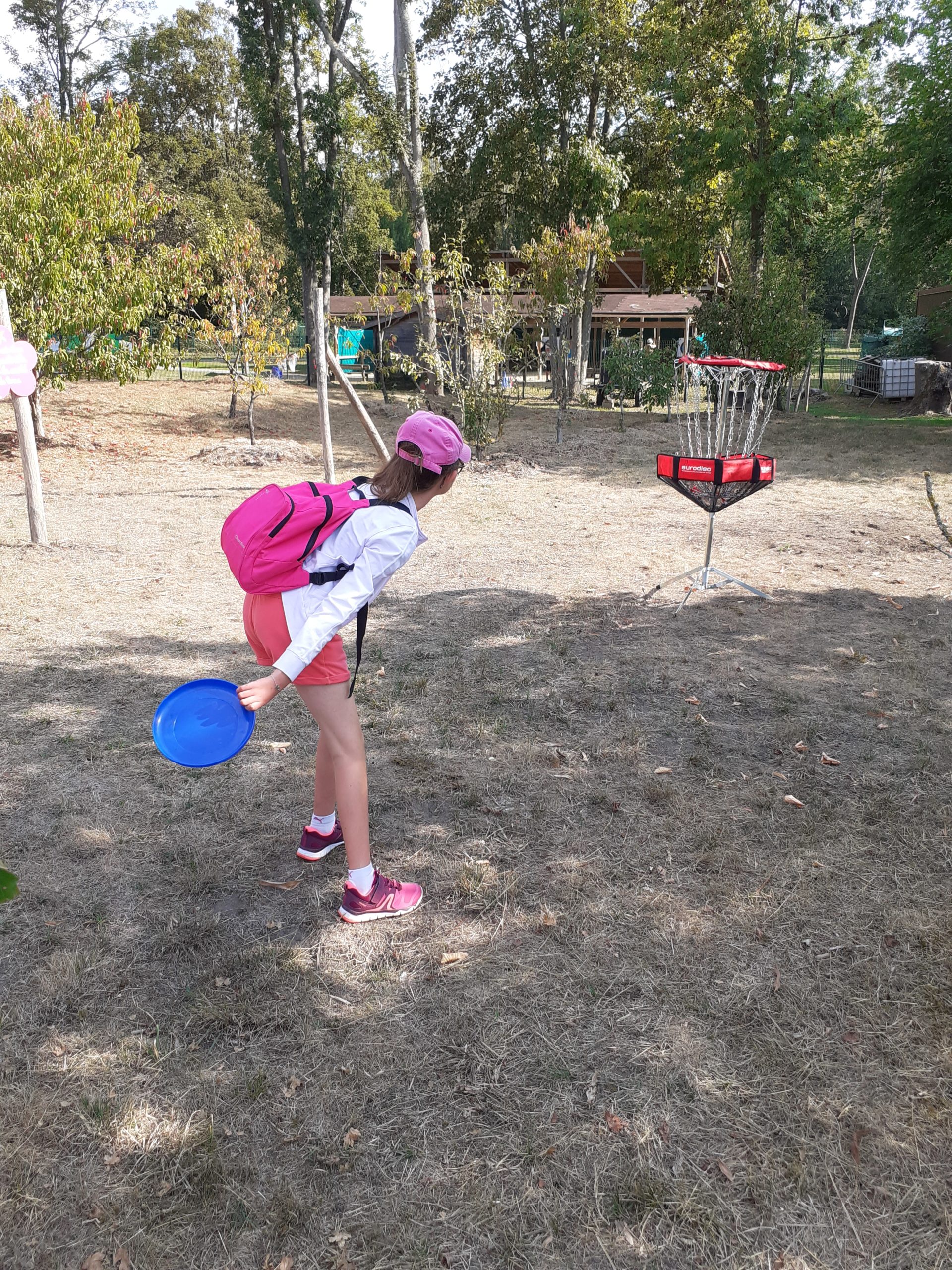 Une enfant lance un frisbee